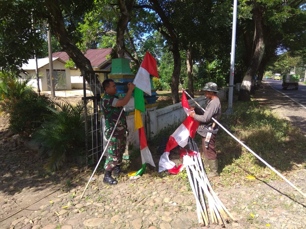 BABINSA PASANG BENDERA UMBUL-UMBUL DIBANTU WARGA